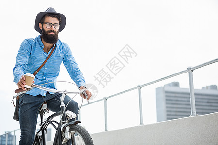 骑自行车的嬉皮士眼镜阳台男人绘图计算机胡须驼色夹克商业商务图片