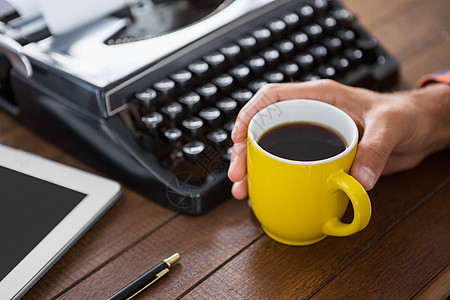 一个男人在喝咖啡手指木桌键盘技术信件思维软垫作家专注衬衫背景图片