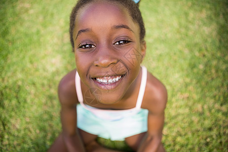 一个可爱的混种女孩的肖像 微笑和坐在草地上图片