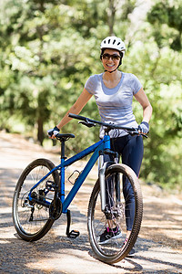 越野自行车女人笑着装着骑自行车草地踪迹活动快乐风景越野冒险家女士娱乐闲暇背景