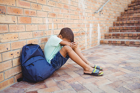 悲哀的男孩 他的头跪在膝上悲伤教育忧郁男生小学生楼梯苦难哭泣瞳孔幼儿园图片