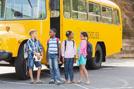 微笑的孩子们一起站在校车前学校学生女学生休闲快乐校车沟通服装学习小学图片