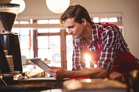 使用数字平板电脑的服务员触摸屏咖啡机柜台互联网技术男人网络沟通男性服务图片