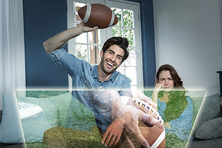 男人的综合形象正在他无聊的妻子旁边看美式足球比赛图片