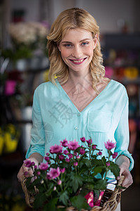 快乐的花女 拿着一篮子鲜花店铺工人职业商业女士植物金发女郎花园员工植物学图片