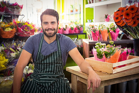 花店的男花匠中心桌子男人花朵零售花园快乐工人服务微笑图片