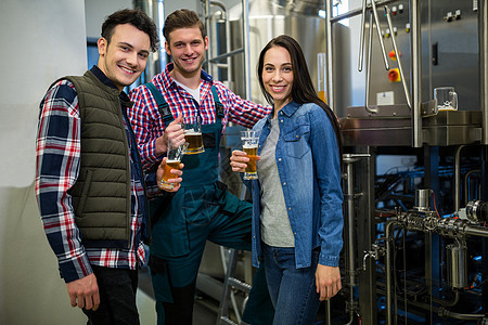 在酿酒厂装着啤酒杯的酿酒者职员朋友们伙伴团队机械合作女性工人食品玻璃图片