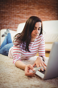 从事网上购物的年轻妇女信用卡休闲沙发技术住所女性沟通网上购物笔记本互联网图片