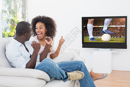 足球运动员踢球的复合图象齿轮男人女士夫妻男性蓝色电视球衣快乐感情图片