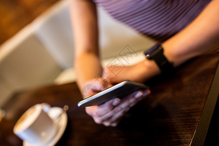 使用手机的妇女中流体桌子咖啡餐厅休闲沟通电话活动杯子服装技术图片