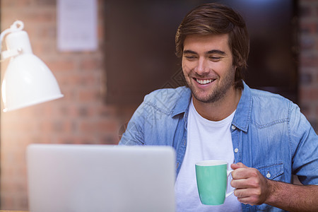 商务人士在笔记本电脑工作时喝咖啡职场创意饮料杯子技术快乐微笑商务咖啡商业图片