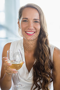 握着啤酒杯的微笑女人的肖像桌子酒店女性快乐奢华乐趣酒吧白酒女士酒杯图片