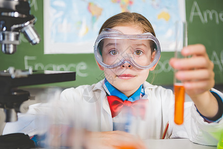 在实验室进行化学实验的女学生 大学女生防护眼镜小学工作服液体专注桌子小学生课堂女孩女性图片