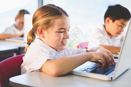 在课堂上使用笔记本电脑的学童女孩校服学生小学班级同学们互联网技术男性学习图片