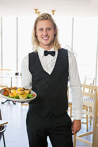 在餐厅里拿着一盘食物的服务员制服男人食品马甲饮料酒吧男性商业咖啡店酒店图片