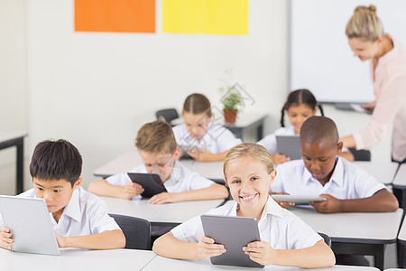 学生在课堂上使用数字平板电脑学校小学生教育制服服装快乐混血网络男生女孩图片