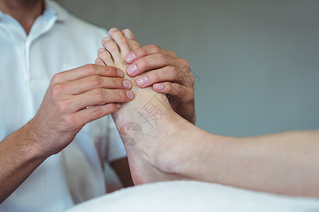 给一个女人做脚按摩的理疗师从业者医生保健职业骨科服务按摩师护理病人压力图片