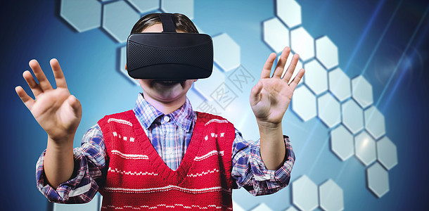 年轻男孩身穿红色跳跃器的复合图像和虚拟现实头盔计算喜悦男生双手青少年六边形耳机计算机技术蓝色图片