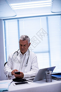 坐在平板上并使用移动电话的医生外套医院老年电脑卫生职业咨询手机技术沟通图片