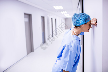 伤心外科医生靠在走廊的墙上治疗诊所住院医学互联网悲伤专注职场疾病手术背景图片