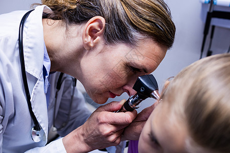 女医生用显眼镜检查病人耳朵女孩学家器材专注外套访问医务室女士咨询医疗图片