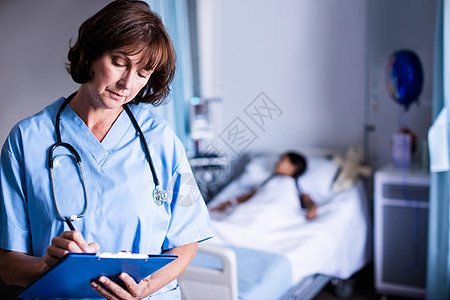 医生在剪贴板上写字服务病人专家职业药物考试混血病房女士报告图片