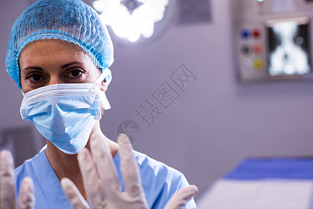 女性外科医生为手术室手术做准备的纵向肖像医院职业操作制服医务室服务情况检查手套手术帽图片