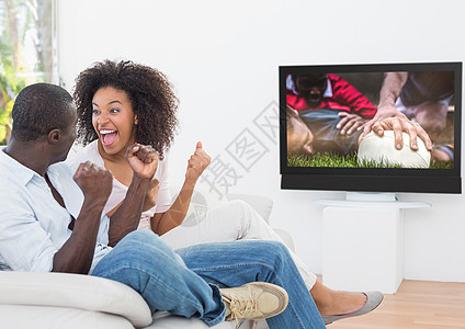 在电视上看橄榄球比赛时欢呼一对情侣图片