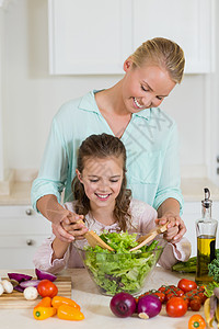 母亲和女儿在家厨房做沙拉 在厨房准备沙拉亲密感切菜板感情蔬菜勺子胡椒台面女性童年现实图片