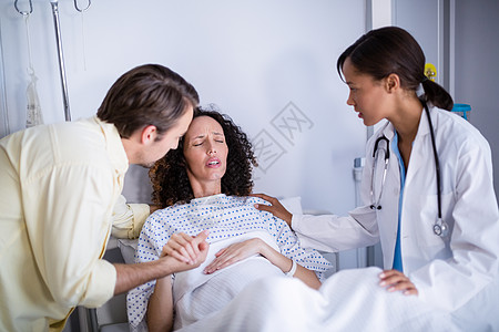 医生和男人在病房中抚慰孕妇卫生互动感情医院孕产孕妇装混血服务劳动男性图片