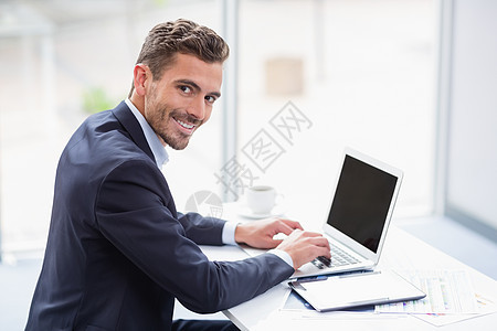 在办公桌上使用笔记本电脑对一名商务人士的肖像图片