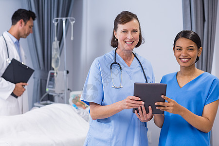 手持数码平板电脑的微笑医生和护士的肖像图片