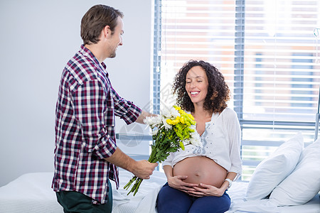 男人在病房里给他的孕妇送一束鲜花卫生指导医院女性等待惊喜医疗怀孕病床快乐图片