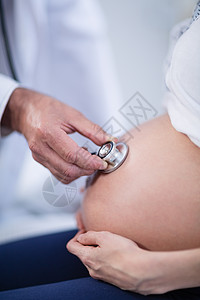 医生在病房用听诊器检查孕妇肚子腹部孕妇装医院怀孕工作专家访问体格休闲女性保健图片