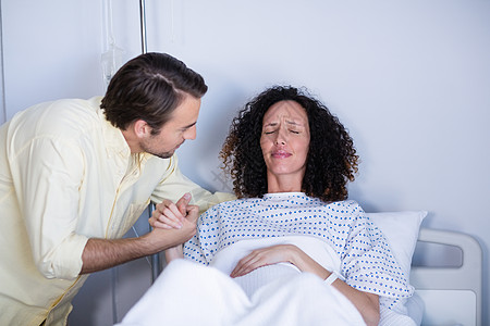在病房分娩期间抚慰孕妇的男子孕产疼痛病号女性亲密感怀孕劳动医疗夫妻医务室图片