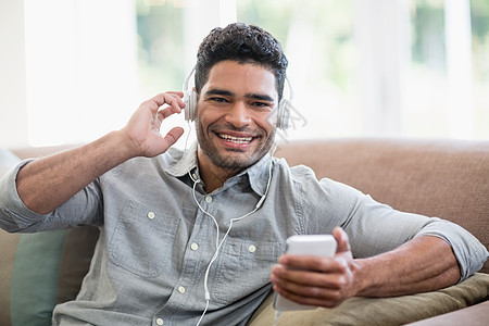 男人在家里客厅用手机听音乐 在家客厅听音乐阅读技术男性音乐互联网享受电话快乐娱乐听力图片