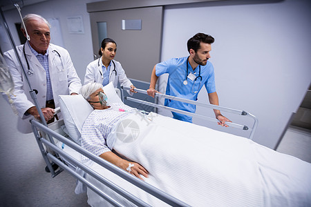 医生和护士在走廊推推紧急担架床专家咨询男人情况病人男性放射科肢体保健医院图片