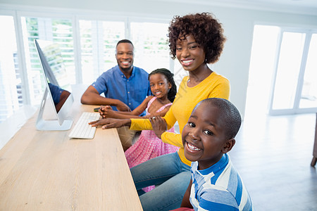 幸福的家庭在家里的客厅里使用电脑男人公寓技术男生沟通女儿住所女士房子互联网图片