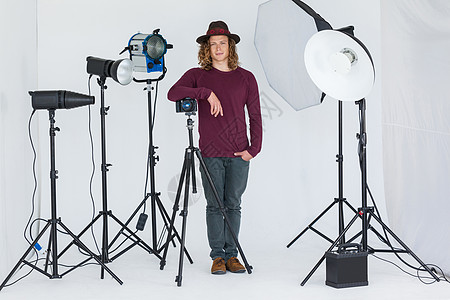 摄影棚里的摄影师站着灯光亲密感三脚架屏幕单反技术男性服装休闲现实图片