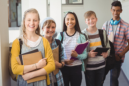 一群带着笔记本的微笑学生站在走廊上女性休闲闲暇学校教育中学女学生享受孩子男性图片