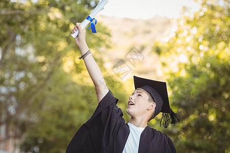 校园里有学位卷轴的毕业男研究生很兴奋图片