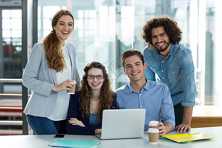 微笑的商务团队在开会时 在笔记本电脑上工作的肖像图片