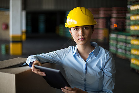 工厂女工厂女工在工厂里拿着数字片板站着制造业工人现实电脑自动化生活技术触摸屏机械女士图片