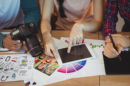 红辣椒创意图形平面设计师在工作期间相互互动的中间区段中网络同事电脑战略照片团队平板青年商业企业背景