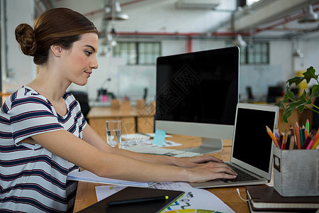 使用膝上型电脑的女性图形设计师现实笔记本桌子办公室手势职场技术快乐生活专注图片