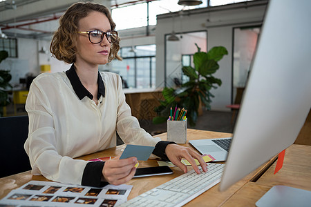 在办公桌工作的女性制图设计师注意力样本职场平板电脑服装女士眼镜商业平面设计师图片
