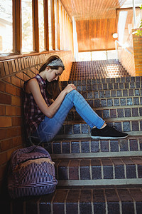 孤单坐在楼梯上悲伤的女学生书包寂寞学校失败小学生享受童年乐趣孤独教育图片