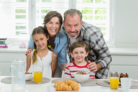 家人在厨房吃早饭时微笑女儿麦片公寓早餐喜悦儿子父亲生活营养母亲图片