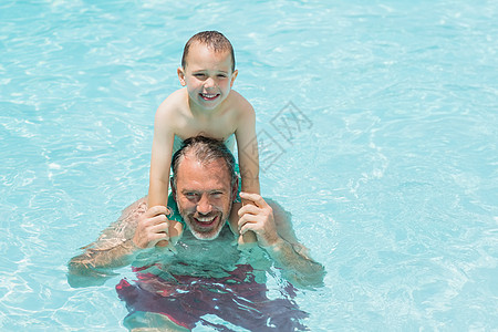 游泳池中父亲和儿子的肖像图片