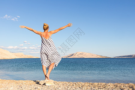 在克罗地亚帕格岛白沙滩上 穿着美丽的条纹暑期衣服 享受下午深夜的节日晚宴图片